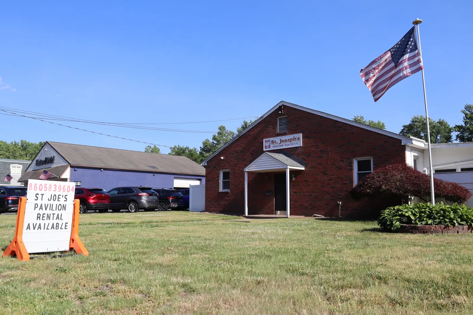 The brick hall and American flag on the club grounds